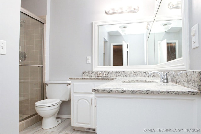 bathroom featuring vanity, toilet, and a shower with door