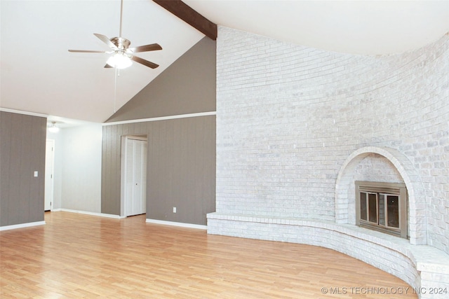 unfurnished living room featuring high vaulted ceiling, light hardwood / wood-style flooring, ceiling fan, a fireplace, and beamed ceiling