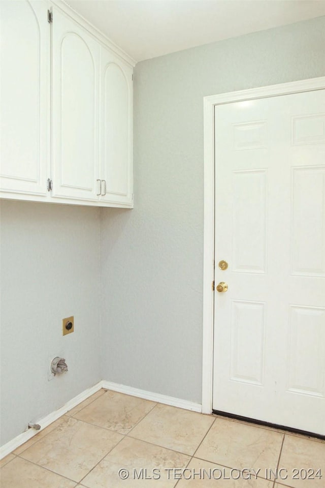 washroom featuring cabinets, light tile patterned floors, and hookup for an electric dryer