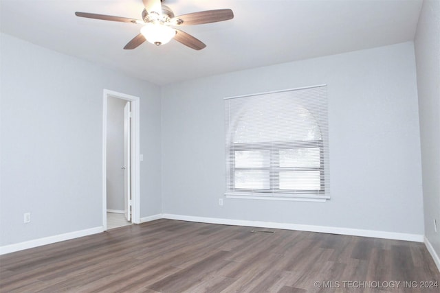 spare room with ceiling fan and dark wood-type flooring