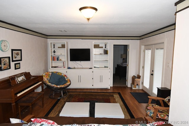 living room featuring dark hardwood / wood-style flooring, built in features, and ornamental molding