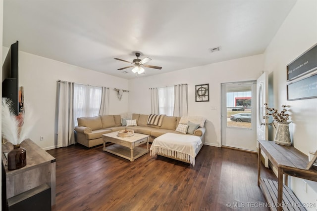 living room featuring ceiling fan and dark wood-type flooring