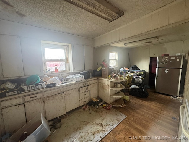 kitchen with stainless steel fridge, a textured ceiling, and a healthy amount of sunlight