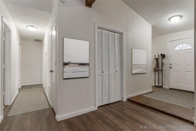 entrance foyer featuring a textured ceiling and dark hardwood / wood-style flooring