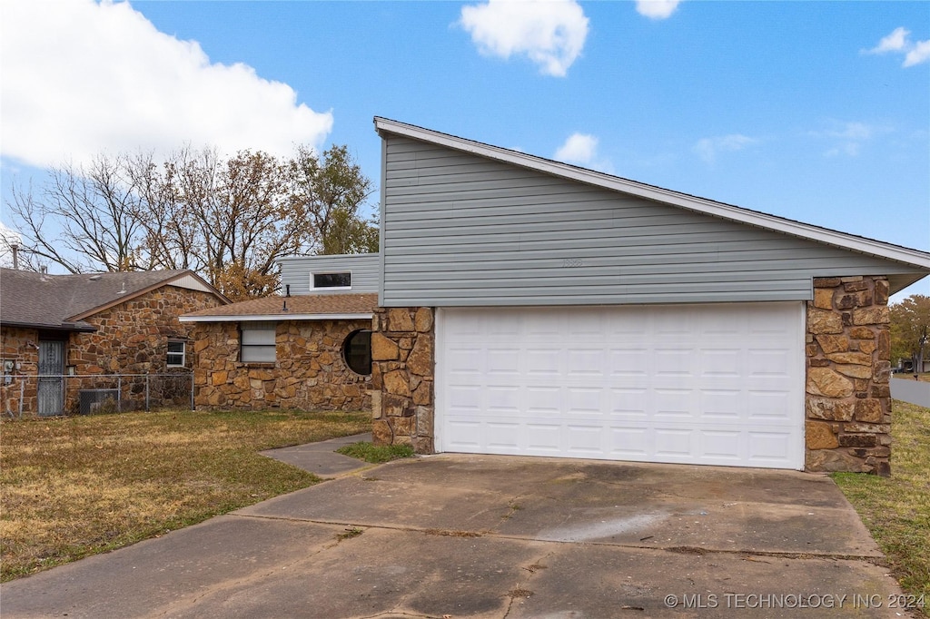 view of side of property with a lawn and a garage