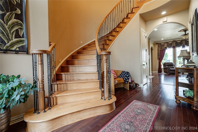 stairs featuring wood-type flooring and ornamental molding