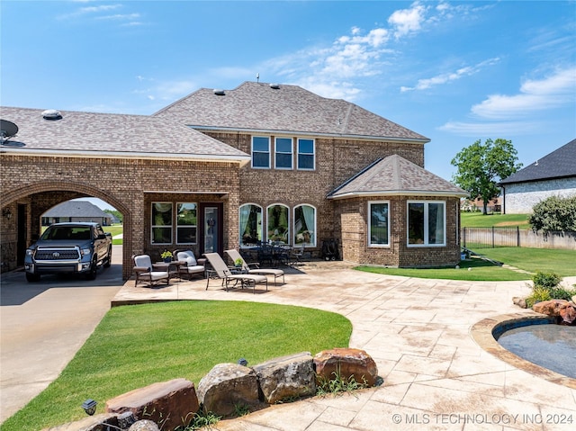 back of house with a yard and a patio