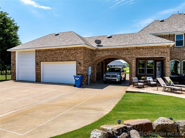 view of front facade with a patio area and a garage