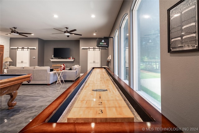 recreation room featuring a barn door, ceiling fan, and pool table