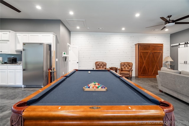 recreation room featuring ceiling fan, a barn door, billiards, and wooden walls