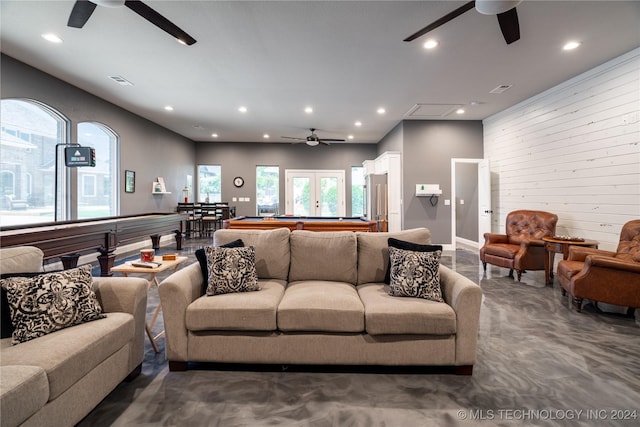 living room featuring billiards, wooden walls, and french doors