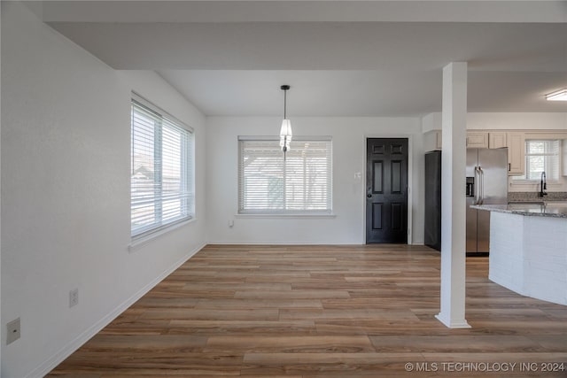 unfurnished dining area featuring light wood-type flooring and sink