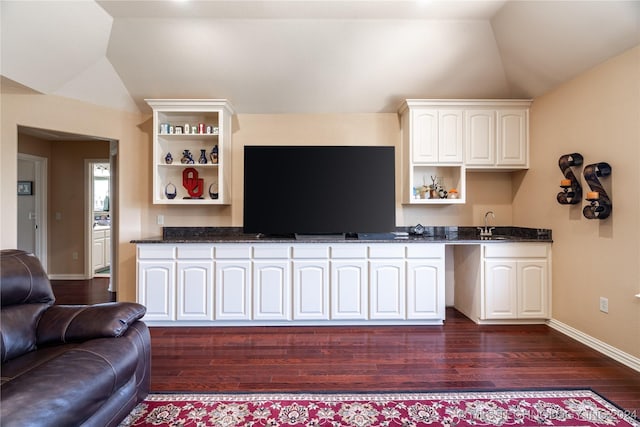 kitchen with dark hardwood / wood-style flooring, vaulted ceiling, and white cabinetry