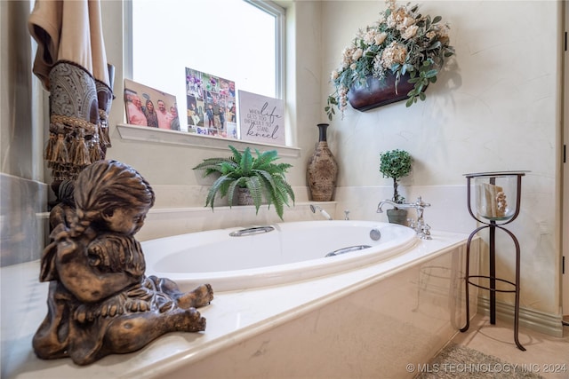 bathroom with tile patterned flooring and a relaxing tiled tub