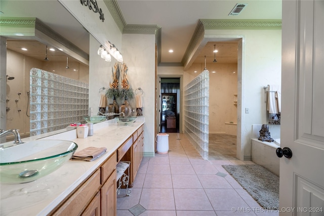 bathroom featuring tile patterned floors, a bathing tub, crown molding, and vanity