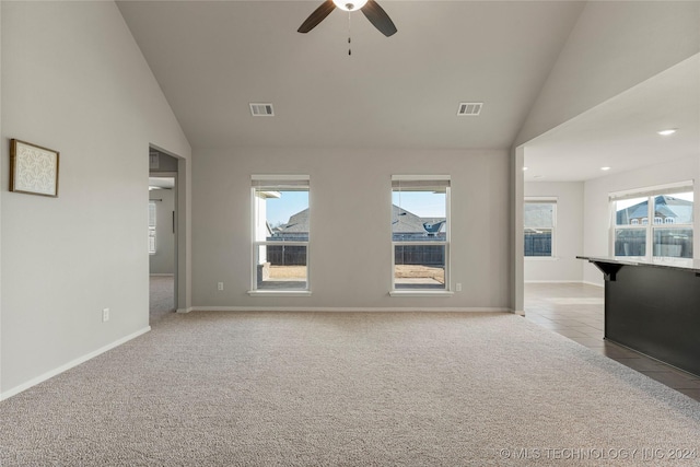 unfurnished living room featuring ceiling fan, light colored carpet, plenty of natural light, and lofted ceiling