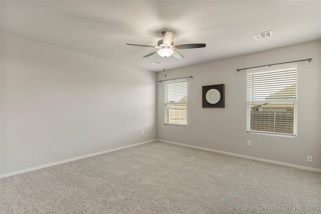 carpeted empty room featuring ceiling fan and a healthy amount of sunlight