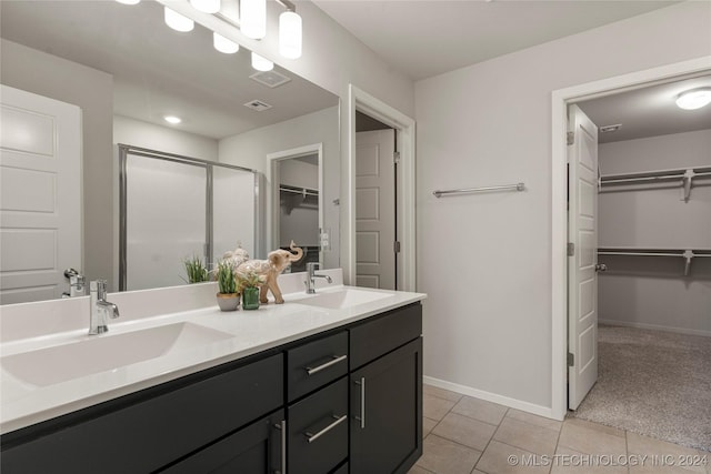 bathroom featuring tile patterned floors, a shower with door, and vanity