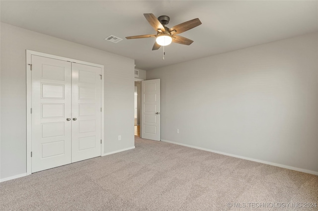 unfurnished bedroom featuring carpet floors, a closet, and ceiling fan