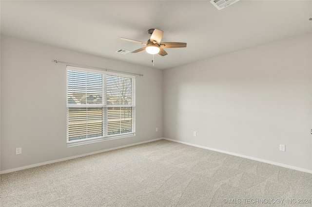 empty room featuring ceiling fan and light colored carpet