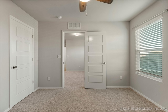 unfurnished bedroom featuring light carpet and ceiling fan