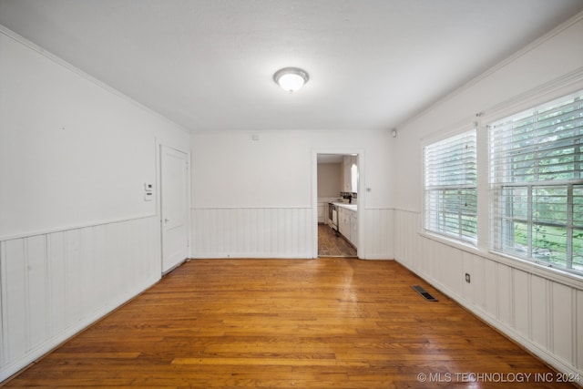 unfurnished room with hardwood / wood-style floors and ornamental molding