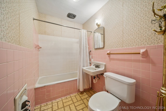 full bathroom featuring sink, toilet, shower / bathtub combination with curtain, tile walls, and heating unit