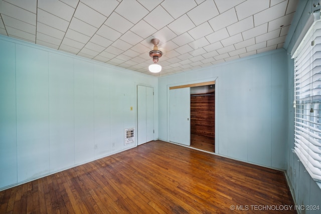 spare room featuring dark hardwood / wood-style flooring, heating unit, and crown molding