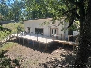 rear view of property featuring a deck and french doors