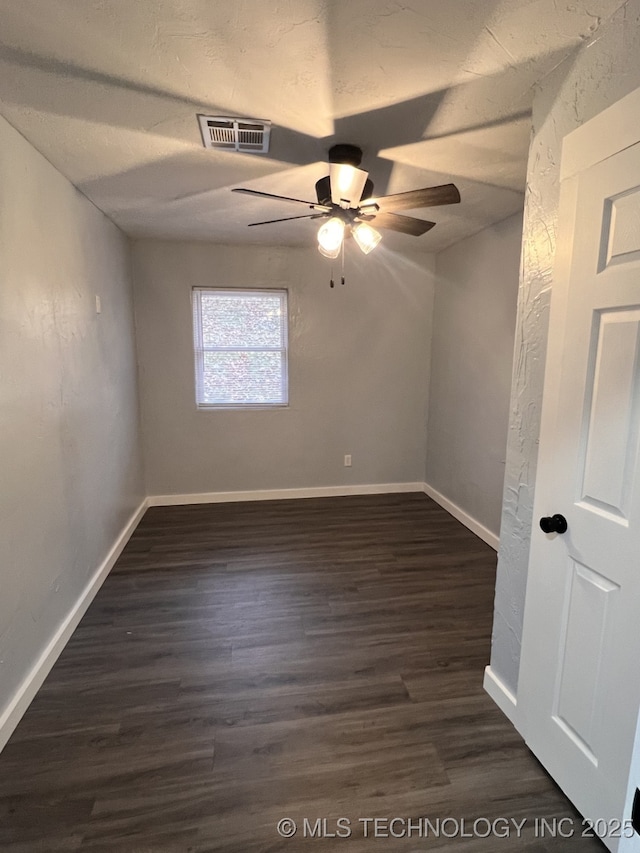 empty room with ceiling fan, dark hardwood / wood-style flooring, and a textured ceiling