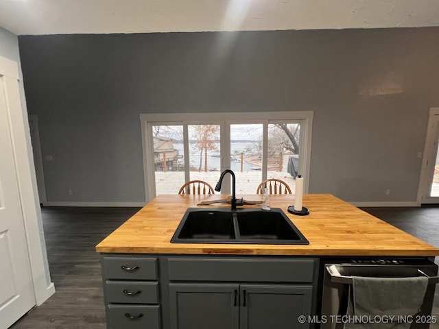 kitchen with dishwashing machine, gray cabinetry, butcher block counters, and sink