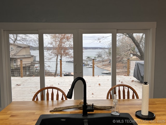 dining space with a wealth of natural light, sink, and a water view