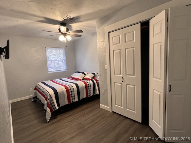 bedroom with a textured ceiling, dark hardwood / wood-style floors, and ceiling fan