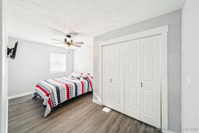 bedroom with ceiling fan, dark hardwood / wood-style floors, and a closet