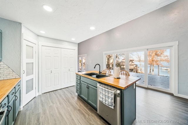 kitchen featuring decorative backsplash, stainless steel dishwasher, sink, light hardwood / wood-style floors, and butcher block counters