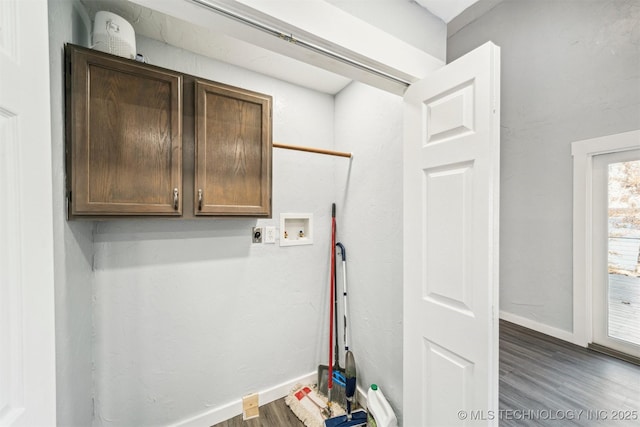 washroom featuring dark hardwood / wood-style floors, cabinets, and hookup for a washing machine