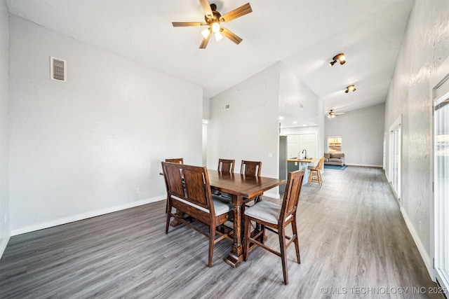 dining room with ceiling fan, dark hardwood / wood-style flooring, and high vaulted ceiling