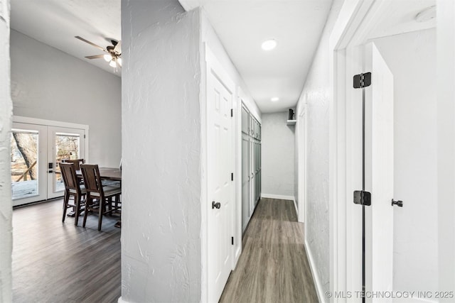 corridor with wood-type flooring and french doors