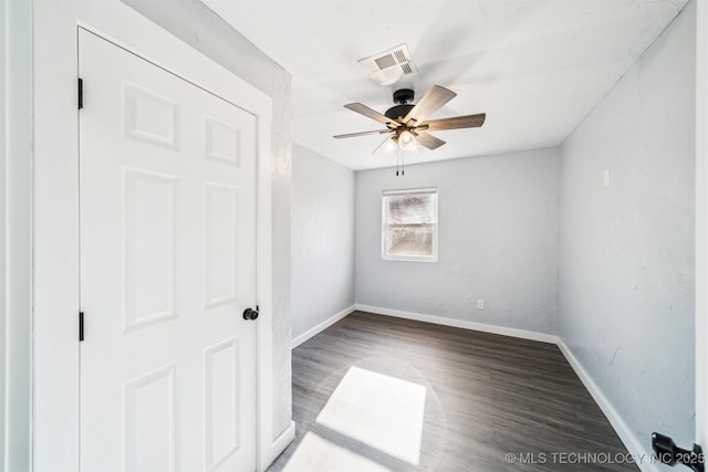 spare room with ceiling fan and dark wood-type flooring