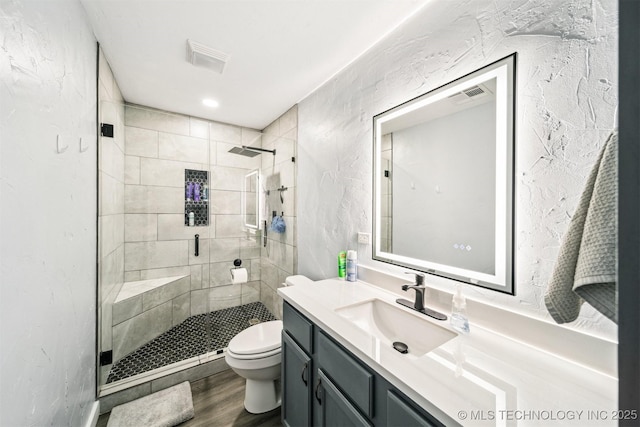 bathroom featuring walk in shower, hardwood / wood-style floors, vanity, and toilet