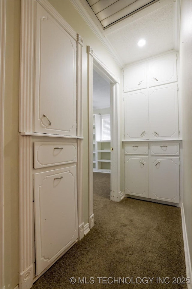 corridor featuring dark colored carpet and ornamental molding