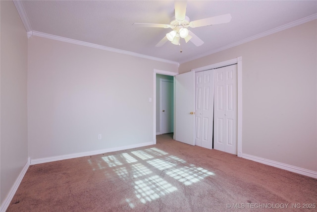 unfurnished bedroom with carpet floors, a closet, ceiling fan, and crown molding