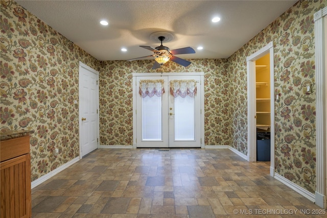 empty room featuring french doors, a textured ceiling, and ceiling fan