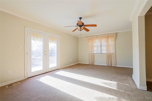 carpeted empty room with crown molding, french doors, and ceiling fan