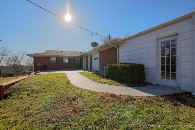 view of property exterior featuring a lawn and central AC