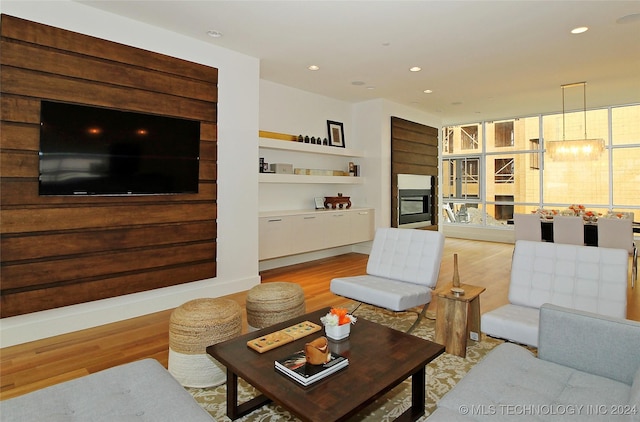 living room with built in shelves and light hardwood / wood-style floors