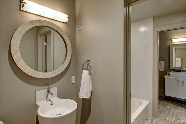 bathroom featuring sink, hardwood / wood-style floors, and a washtub