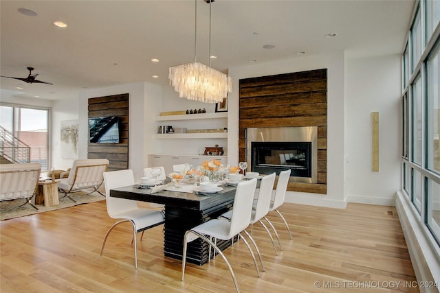 dining room with light wood-type flooring and ceiling fan with notable chandelier