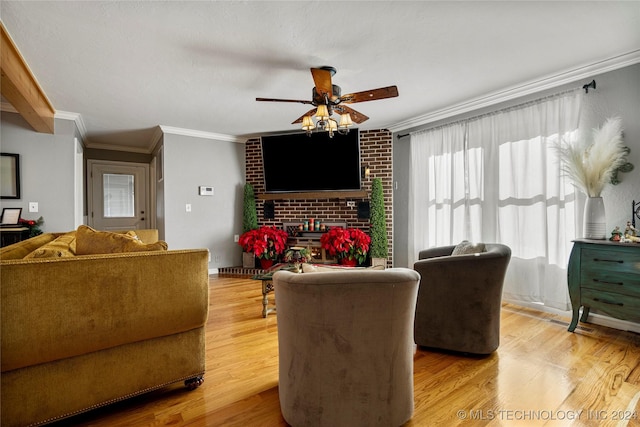 living room featuring hardwood / wood-style floors, a brick fireplace, ceiling fan, and crown molding