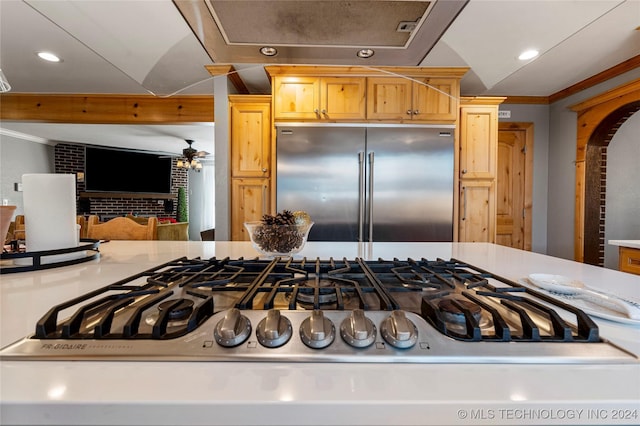 room details with ceiling fan, light brown cabinets, stainless steel built in refrigerator, and ornamental molding